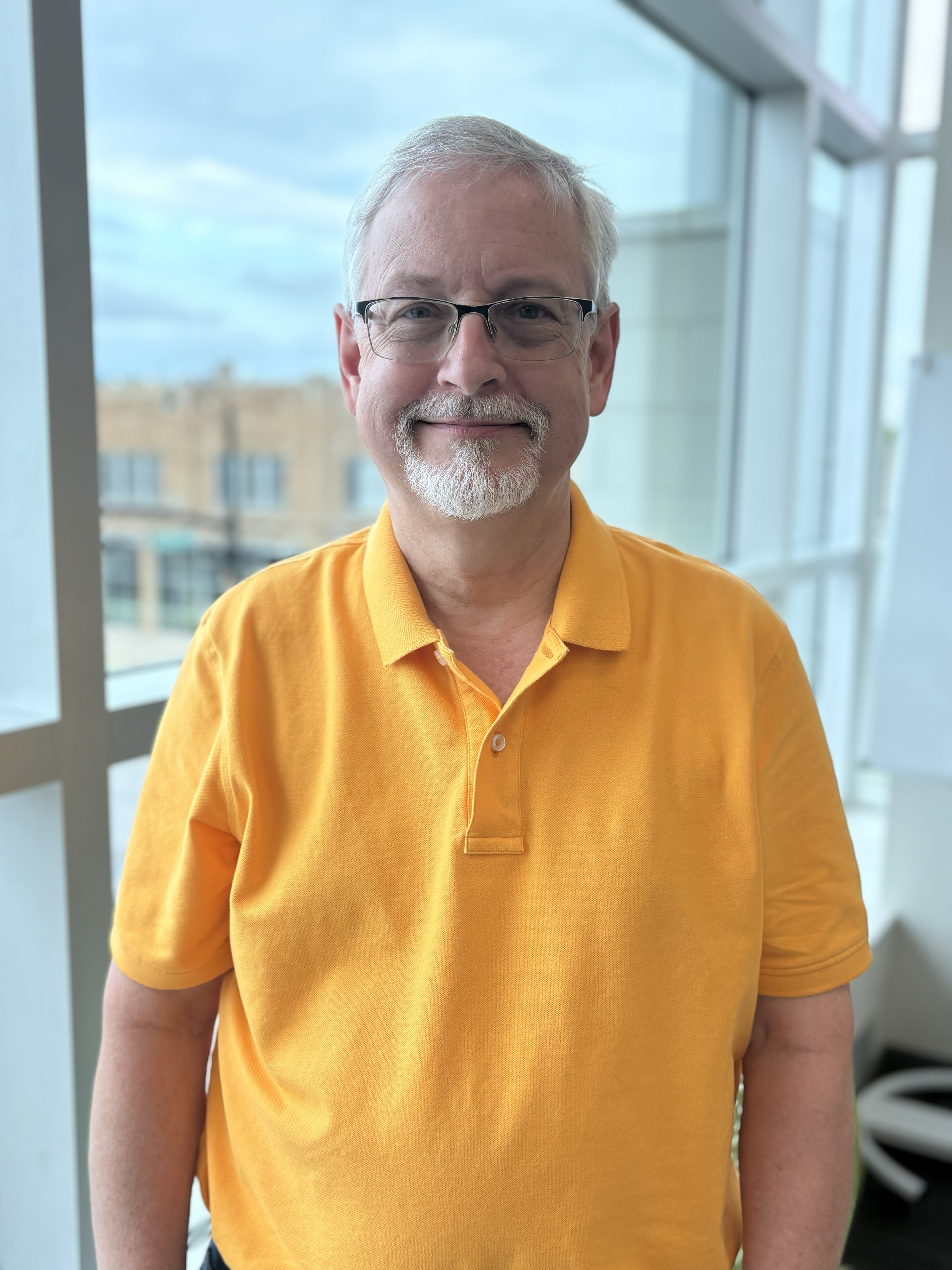 Scott in glasses and yellow polo smiles for the camera.